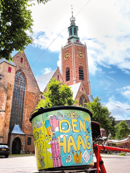 Den Haag Stadsemmer achterop een fiets voor de Grote of Sint-Jacobkerk in Den Haag